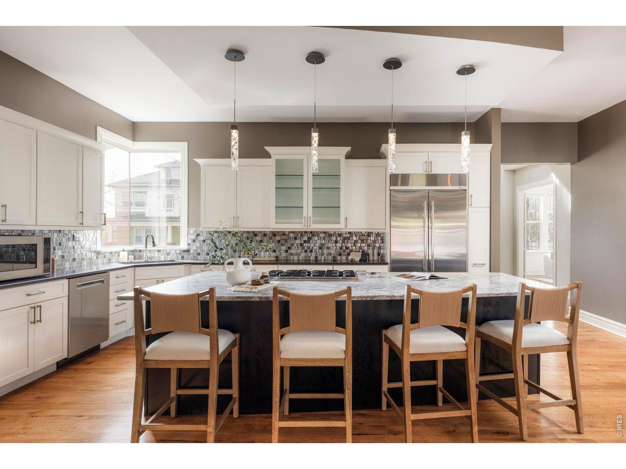 Image 2: The kitchen serves as the heart of the home with a large island, generous counter space, Wolf double ovens, and a walk-in pantry. Image 2: The kitchen serves as the heart of the home with a large island, generous counter space, Wolf double ovens, and a walk-in pantry.