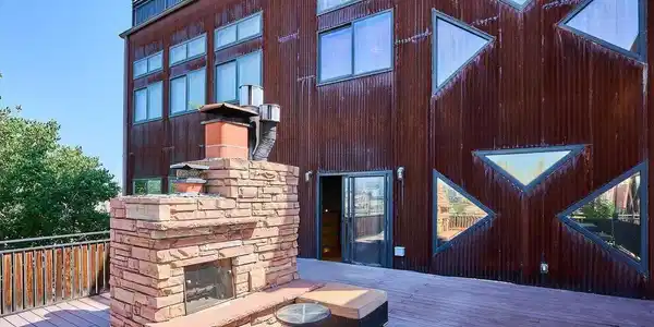 Image 3: Large upper deck with a view of the fireplace and the building