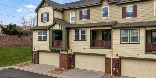 Image 3: Back of home showing covered deck and 2 car garage Image 3: Back of home showing covered deck and 2 car garage