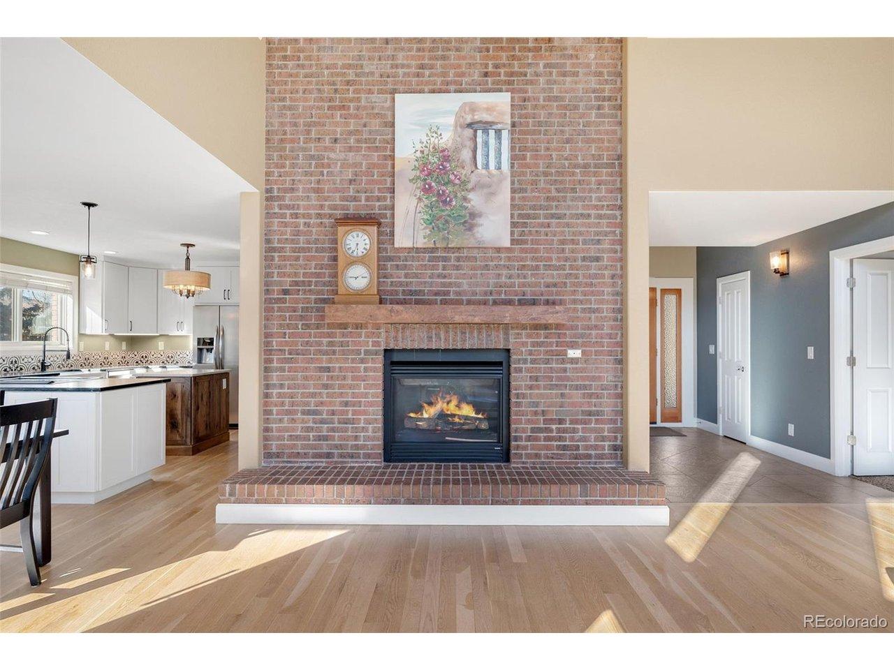 Image 4: The brick fireplace is the focal point of the living room and moves vertically through every level of the home.