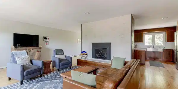 Image 3: Upper level living room with luxury vinyl plank floors, gas fireplace and views of the mountains off the private deck