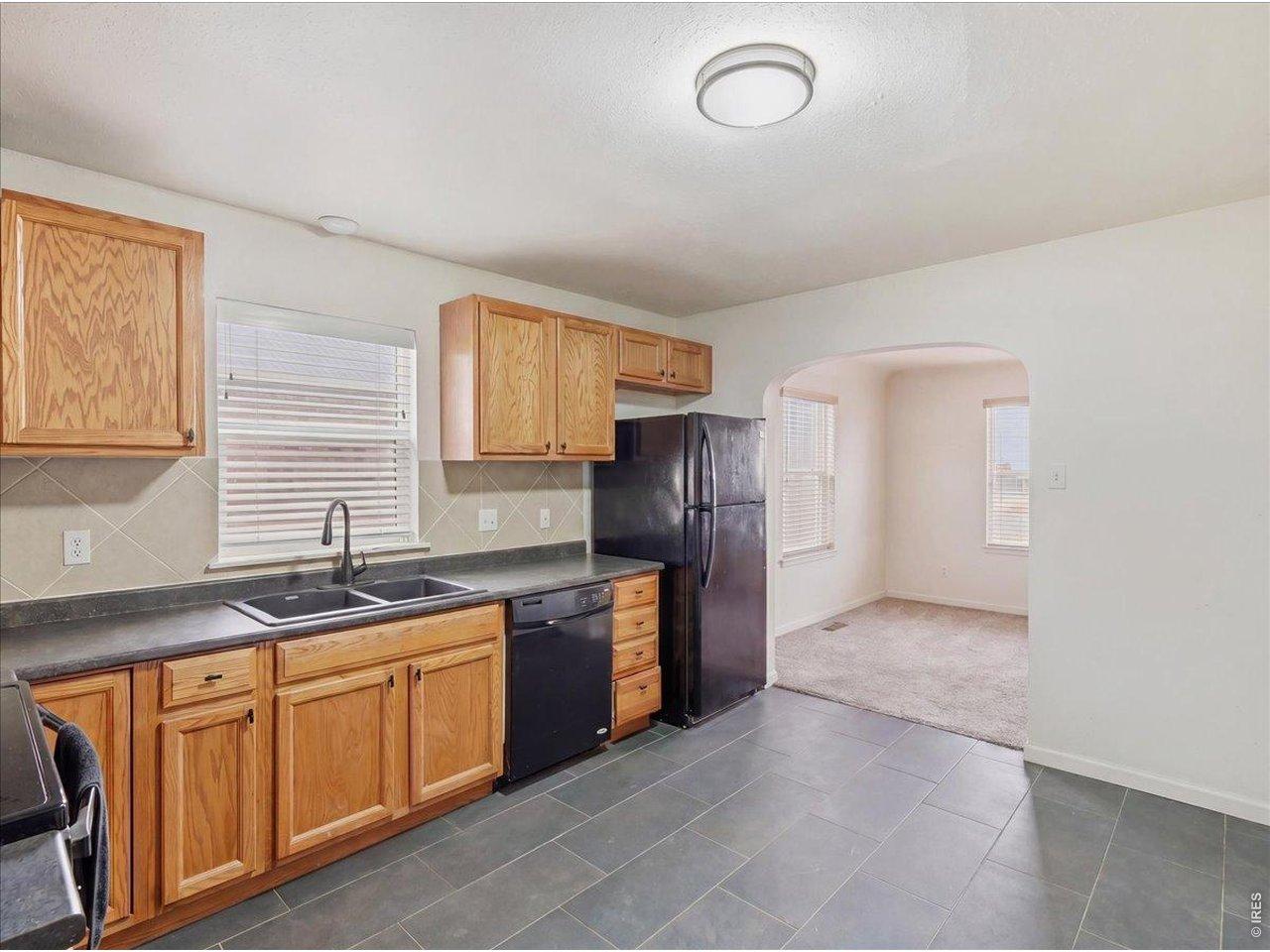 Image 3: New tile floors in 2024. Oak cabinets and black appliances Image 3: New tile floors in 2024. Oak cabinets and black appliances