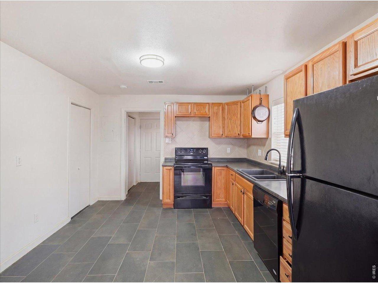 Image 4: New tile floors in 2024. Oak cabinets and black appliances Image 4: New tile floors in 2024. Oak cabinets and black appliances