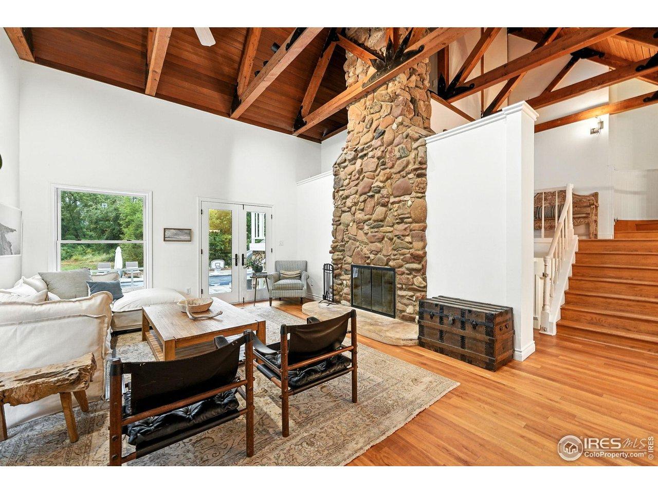 Image 4: Wood burning fireplace in main living area with two sets of doors to patio/pool area Image 4: Wood burning fireplace in main living area with two sets of doors to patio/pool area