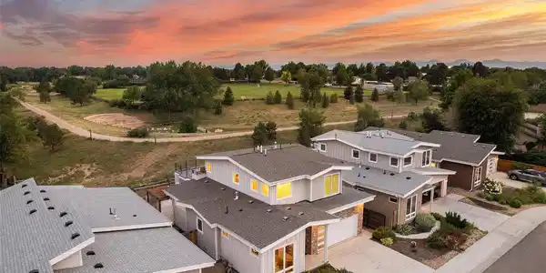 Image 2: Elevated aerial showcasing the home's unique setting backing to the Colorado Academy campus with no direct rear residential neighbors and views toward the Front Range. Image 2: Elevated aerial showcasing the home's unique setting backing to the Colorado Academy campus with no direct rear residential neighbors and views toward the Front Range.