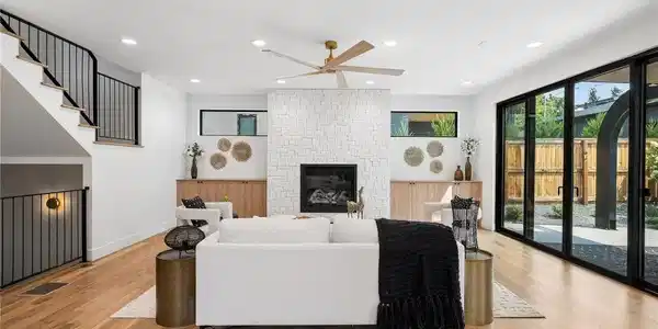 Image 4: Expansive great room + wide plank wood floors + striking fireplace + walls of glass
