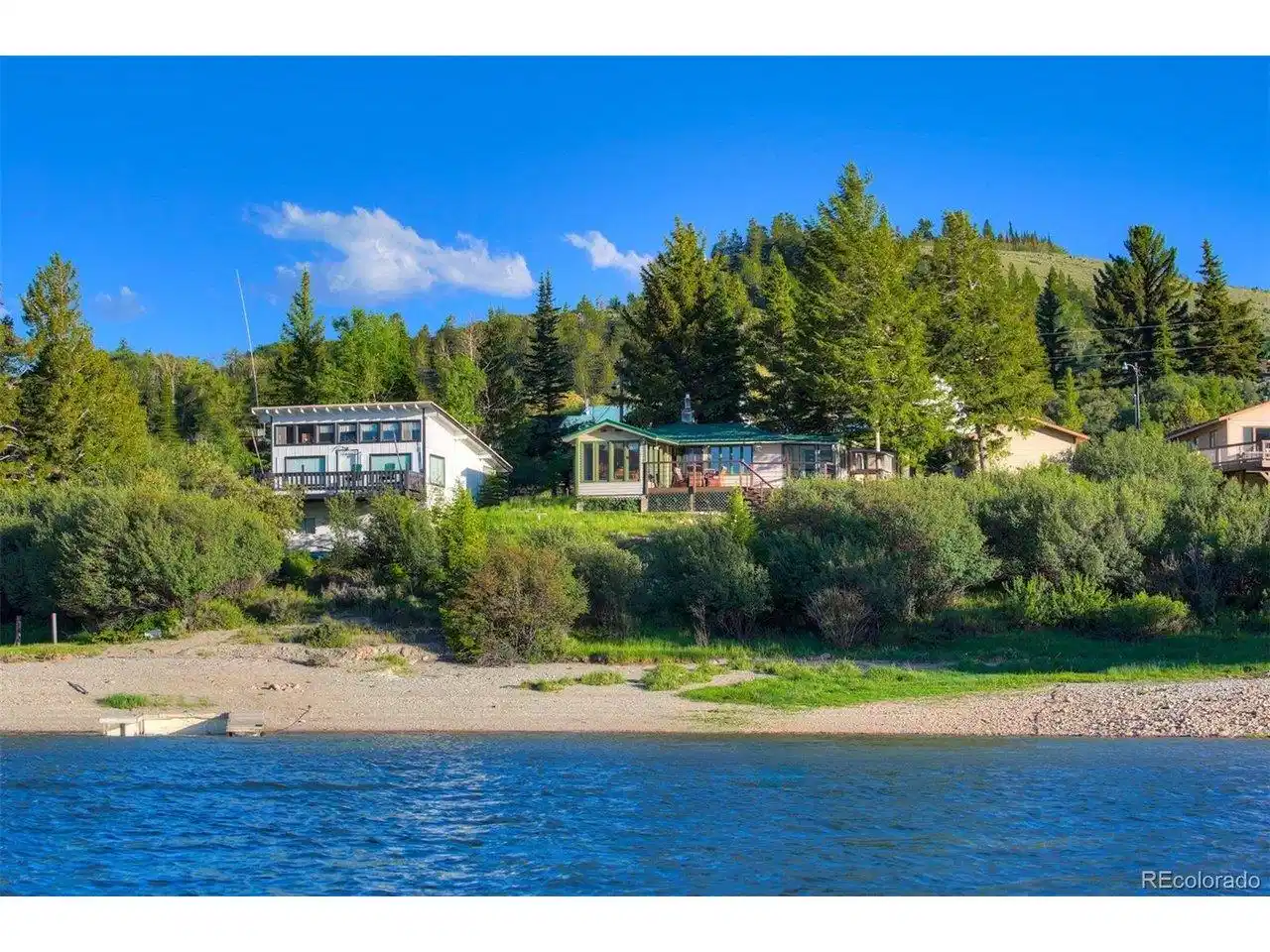 Image 1: Home looking from the water. Photos were taken in June 2024 and are representative of seasonal conditions. Image 1: Home looking from the water. Photos were taken in June 2024 and are representative of seasonal conditions.
