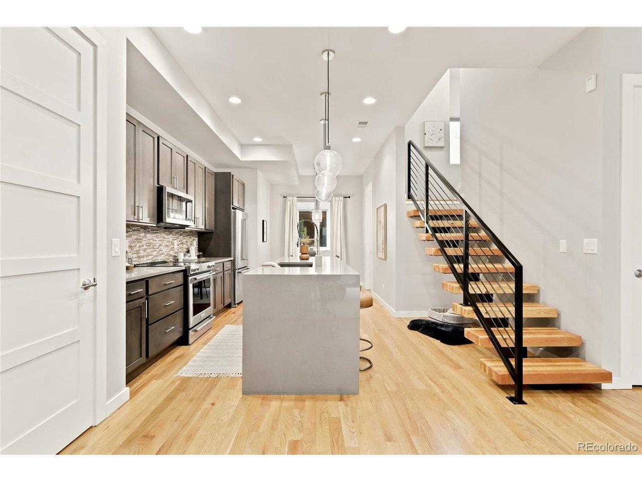 Image 3: Floating oak-and-steel staircase anchors the open main level