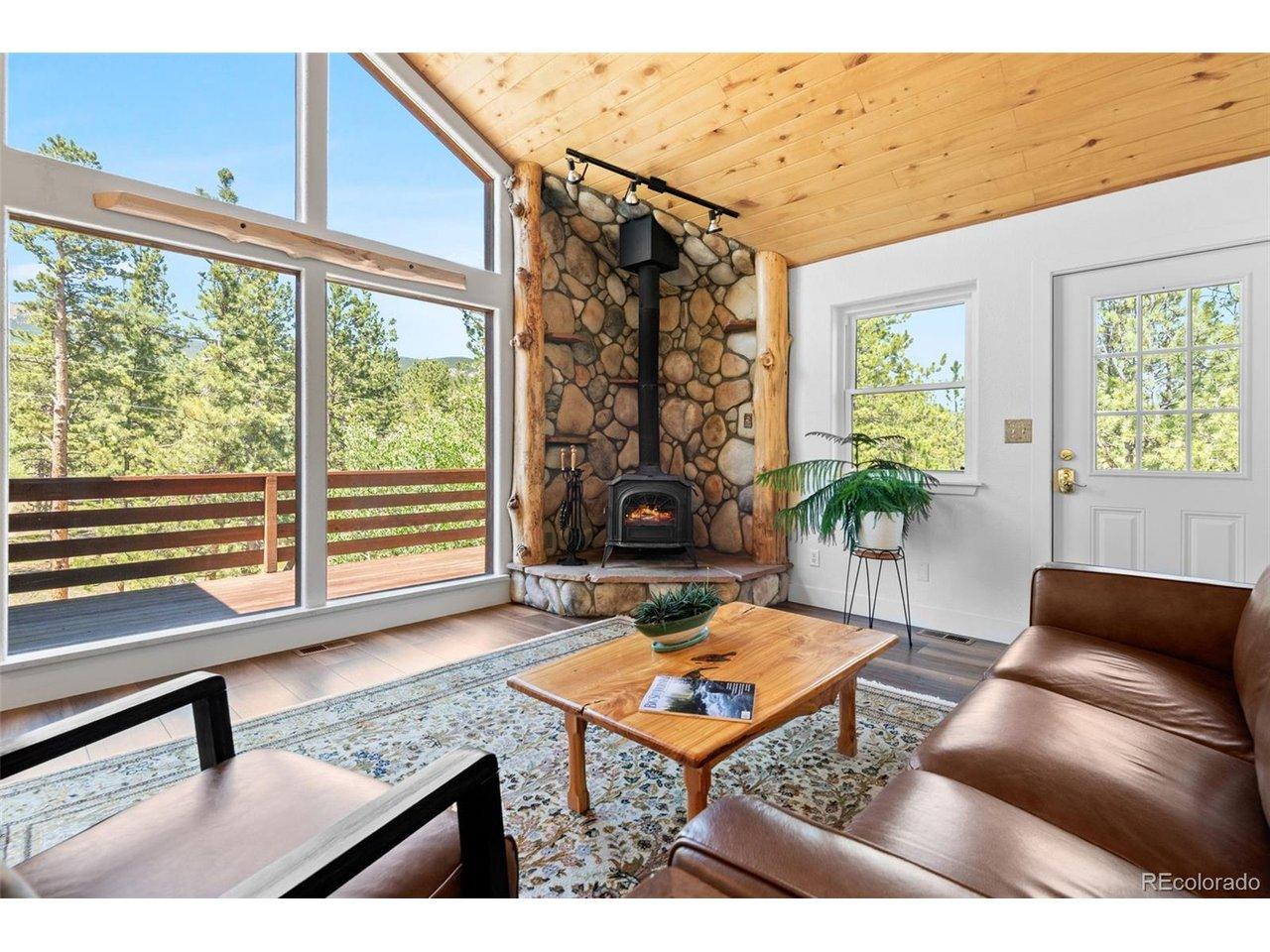 Image 3: Warm and welcoming living room with a wood-burning stove and direct views of the National Forest. Image 3: Warm and welcoming living room with a wood-burning stove and direct views of the National Forest.