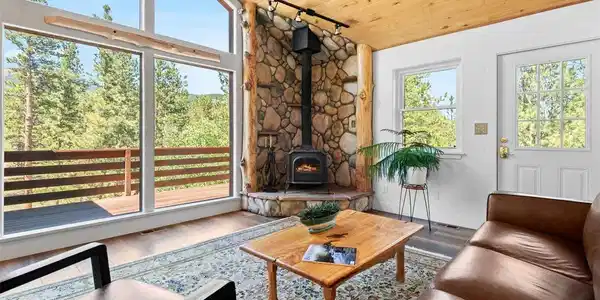 Image 3: Warm and welcoming living room with a wood-burning stove and direct views of the National Forest. Image 3: Warm and welcoming living room with a wood-burning stove and direct views of the National Forest.