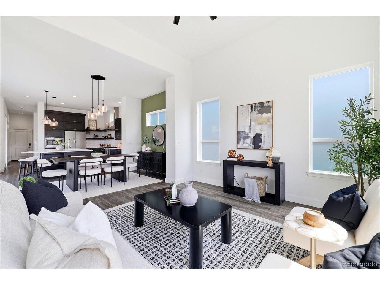 Image 4: The open-concept main level seamlessly connects the living room, dining area, and kitchen beneath dramatic ceiling height. Image 4: The open-concept main level seamlessly connects the living room, dining area, and kitchen beneath dramatic ceiling height.