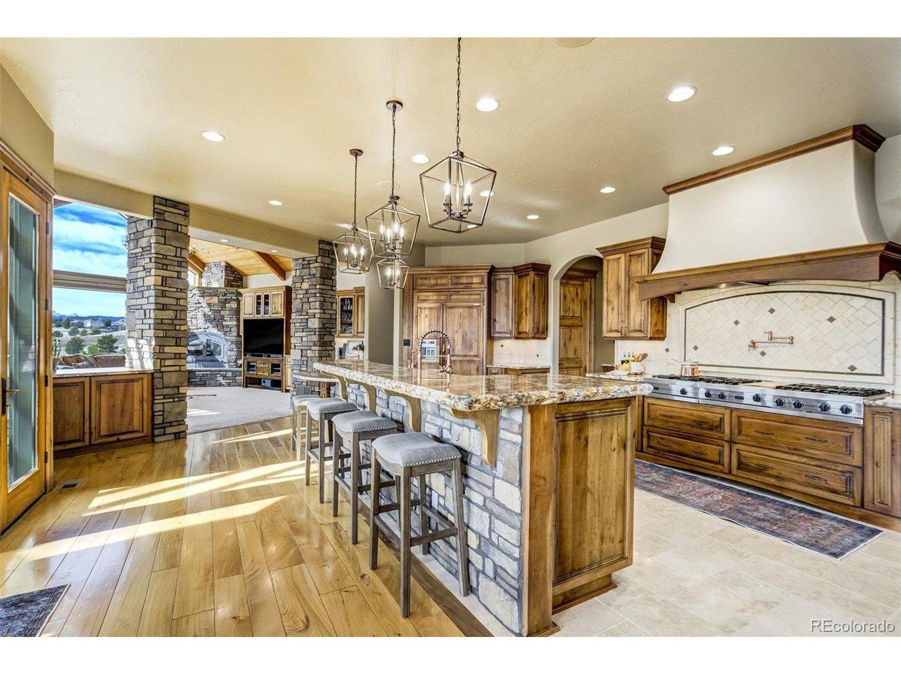 Image 3: Built for gathering and good company, the gourmet kitchen features natural stone surfaces, custom cabinetry, expansive island, and generous pantry space-perfect for family meals or hosting a crowd