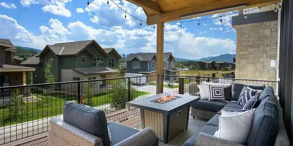 Image 3: The oversized covered deck lives like a second great room, with a fire table, generous seating, and space to gather year-round.