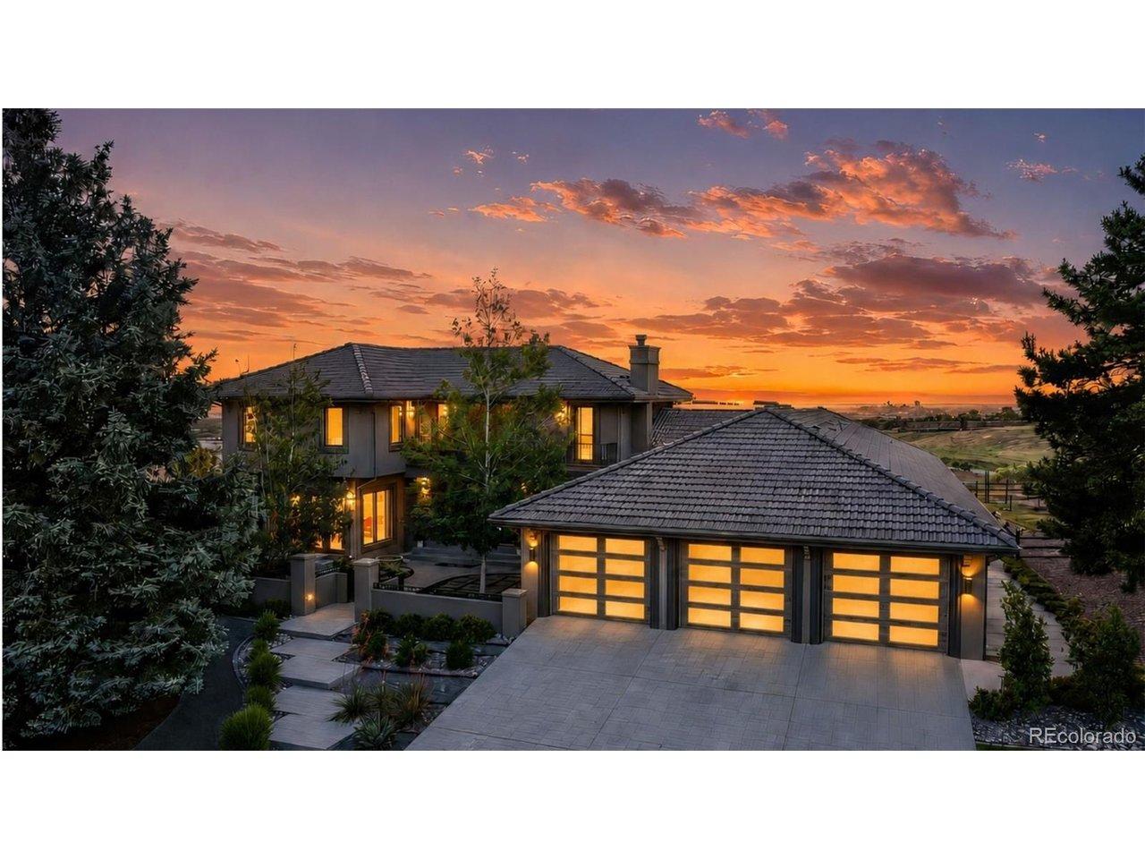 Image 1: Golden hour over 122 Loveland Way. The Spanish tile roof, warm stucco facade, and glass paned garage doors create a stunning glow with Denver and the sunrise in the background. Image 1: Golden hour over 122 Loveland Way. The Spanish tile roof, warm stucco facade, and glass paned garage doors create a stunning glow with Denver and the sunrise in the background.