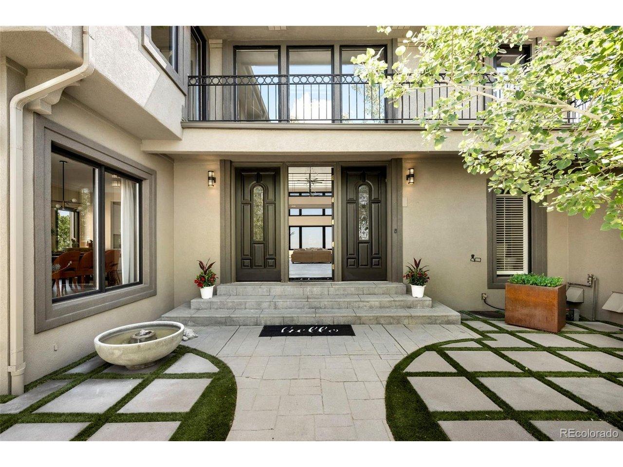 Image 2: The paver courtyard sets the tone before the front door opens. A checkerboard grid of stone and turf, the circular gate motif, and mature aspens signal immediately that this home operates at a different level. Image 2: The paver courtyard sets the tone before the front door opens. A checkerboard grid of stone and turf, the circular gate motif, and mature aspens signal immediately that this home operates at a different level.