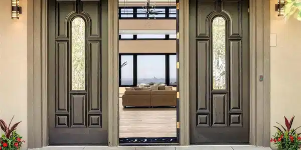 Image 3: The front entry presents arched stained-glass panels frame a sightline that runs straight through the home and out to the Denver skyline. An invitation to experience the luxury inside.