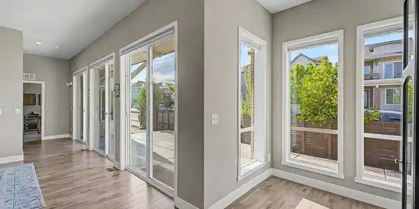 Image 3: Light-filled flex space with vaulted ceilings, wide-plank hardwood floors, and an expansive wall of sliding glass doors opening seamlessly to the outdoor patio - perfect for entertaining or relaxing in the Colorado sunshine. Image 3: Light-filled flex space with vaulted ceilings, wide-plank hardwood floors, and an expansive wall of sliding glass doors opening seamlessly to the outdoor patio - perfect for entertaining or relaxing in the Colorado sunshine.