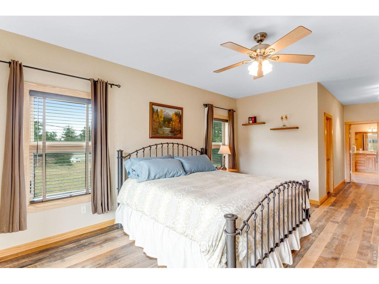 Image 4: Real barnwood flooring in the huge primary suite on the main floor with walk in closet. Image 4: Real barnwood flooring in the huge primary suite on the main floor with walk in closet.