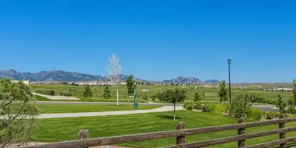 Image 2: With sweeping mountain views stretching across the horizon from the entire west side of the home both inside and out, this impeccably maintained ranch occupies a coveted corner lot on a greenbelt in Whisper Creek, where every day begins and ends with Color