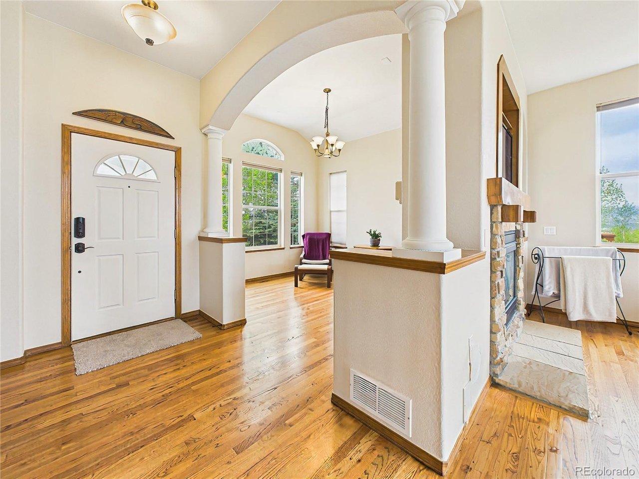 Image 3: Bright and inviting entryway with warm hardwood flooring, elegant columns, and open sightlines into the main living spaces. Image 3: Bright and inviting entryway with warm hardwood flooring, elegant columns, and open sightlines into the main living spaces.