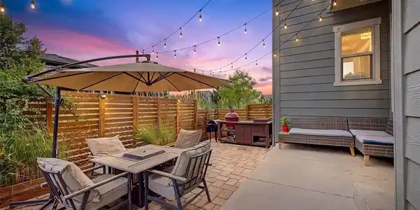 Image 2: Preview: Backyard entertaining area glowing under string lights at dusk Image 2: Preview: Backyard entertaining area glowing under string lights at dusk