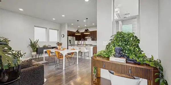 Image 4: Console table vignette with greenery opening into dining and kitchen Image 4: Console table vignette with greenery opening into dining and kitchen