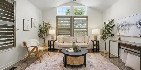 Image 3: Light-filled living room featuring vaulted ceilings, large windows with plantation shutters, updated flooring, and plenty of natural light. Image 3: Light-filled living room featuring vaulted ceilings, large windows with plantation shutters, updated flooring, and plenty of natural light.