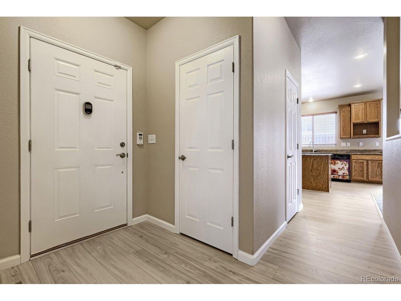 Image 3: interior shot of front door and coat closet, kitchen down the hall Image 3: interior shot of front door and coat closet, kitchen down the hall