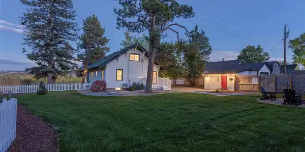 Image 2: Generous, Private Grounds. Enjoy the spacious, meticulously manicured lawn, framed by a classic white picket fence and mature trees. This expansive yard provides the perfect setting for recreation, entertaining, and private enjoyment. Backyard and back of Image 2: Generous, Private Grounds. Enjoy the spacious, meticulously manicured lawn, framed by a classic white picket fence and mature trees. This expansive yard provides the perfect setting for recreation, entertaining, and private enjoyment. Backyard and back of