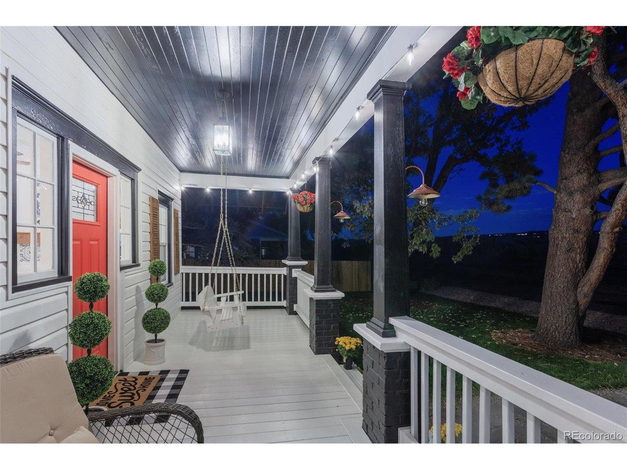 Image 4: The Quintessential Front Porch. Imagine unwinding on this delightful covered porch, complete with a porch swing and elegant string lighting. It's the ideal locale for morning coffee or an evening cocktail, offering an extension of your sophisticated living
