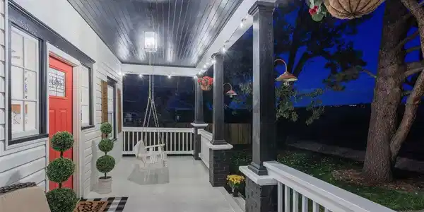 Image 4: The Quintessential Front Porch. Imagine unwinding on this delightful covered porch, complete with a porch swing and elegant string lighting. It's the ideal locale for morning coffee or an evening cocktail, offering an extension of your sophisticated living Image 4: The Quintessential Front Porch. Imagine unwinding on this delightful covered porch, complete with a porch swing and elegant string lighting. It's the ideal locale for morning coffee or an evening cocktail, offering an extension of your sophisticated living