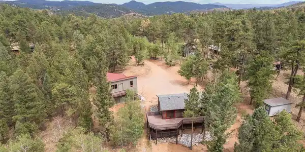 Image 3: From above, the true scale of this mountain sanctuary reveals itself - a private compound wrapped in dense pine forest, with layers of ridgeline stretching to the horizon. Multiple structures dot the wooded acreage, hinting at endless possibilities for sto Image 3: From above, the true scale of this mountain sanctuary reveals itself - a private compound wrapped in dense pine forest, with layers of ridgeline stretching to the horizon. Multiple structures dot the wooded acreage, hinting at endless possibilities for sto