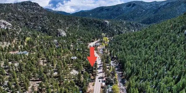 Image 2: Aerial view showcasing the home's proximity to the Big Thompson River and the natural beauty of the canyon.