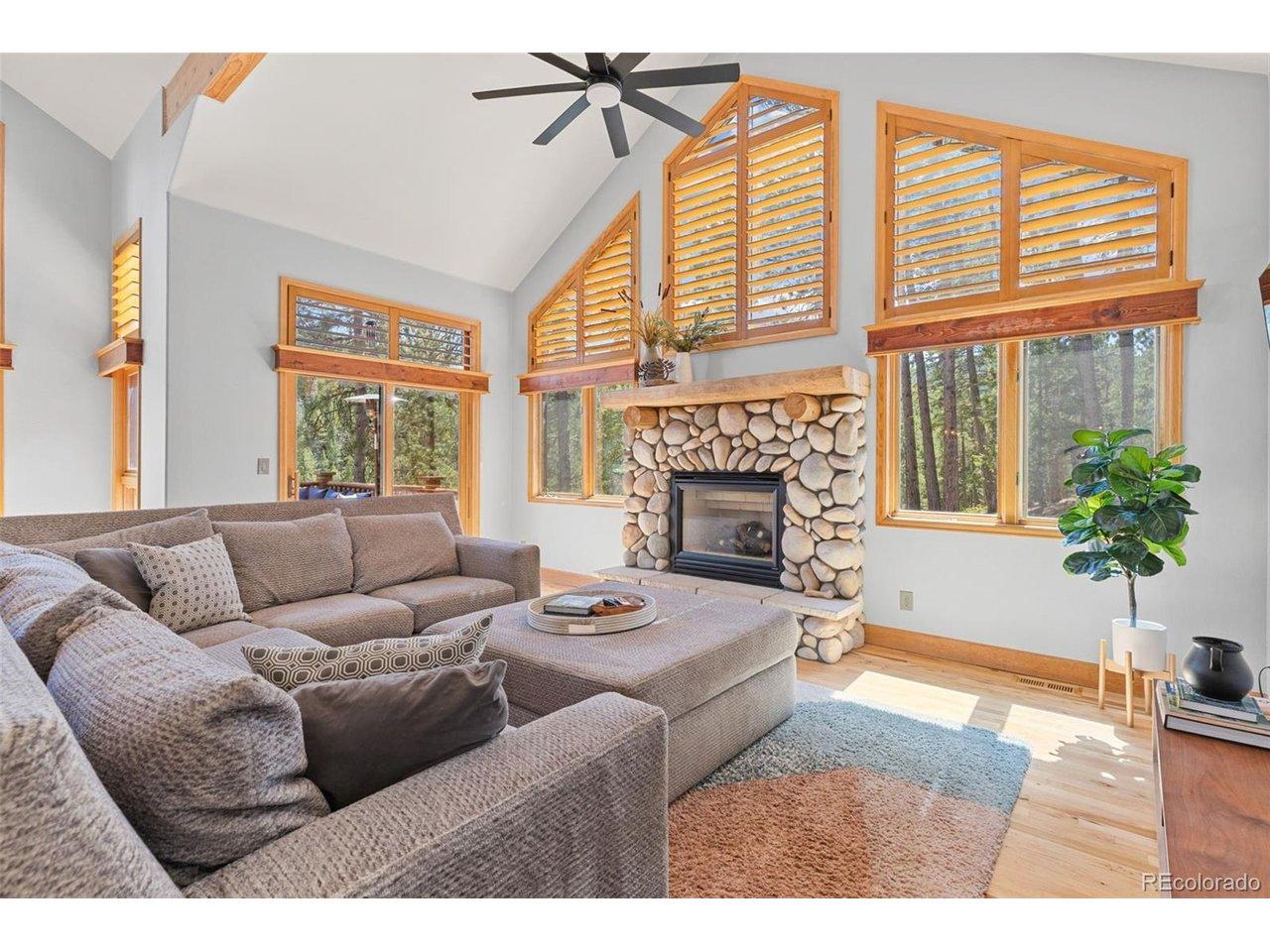 Image 2: Great room with a stone stacked gas fireplace, walls of windows and access to the main level deck. Image 2: Great room with a stone stacked gas fireplace, walls of windows and access to the main level deck.