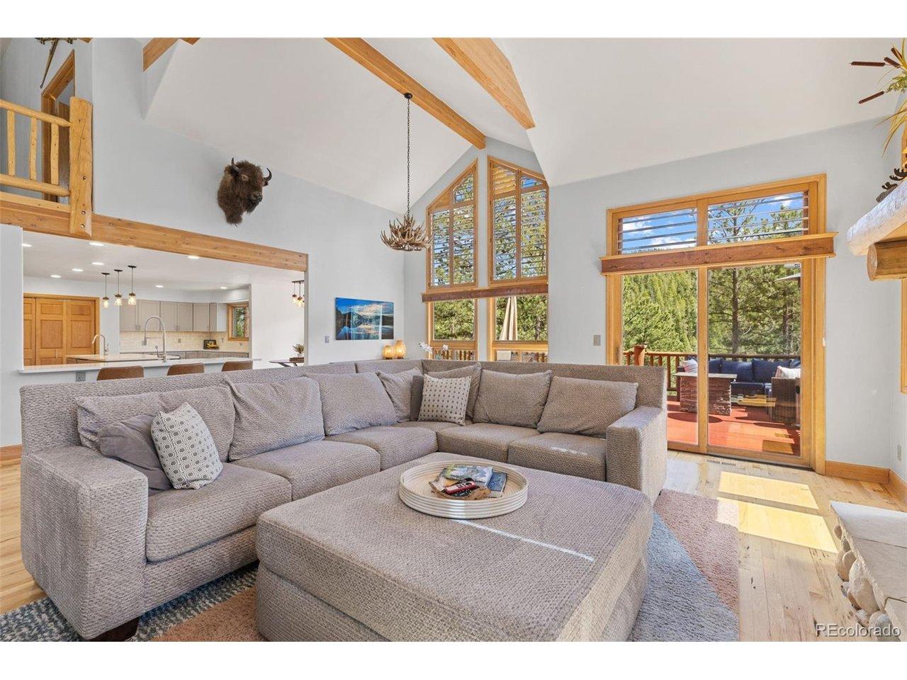Image 3: Great room with a stone stacked gas fireplace, walls of windows and access to the main level deck. Image 3: Great room with a stone stacked gas fireplace, walls of windows and access to the main level deck.