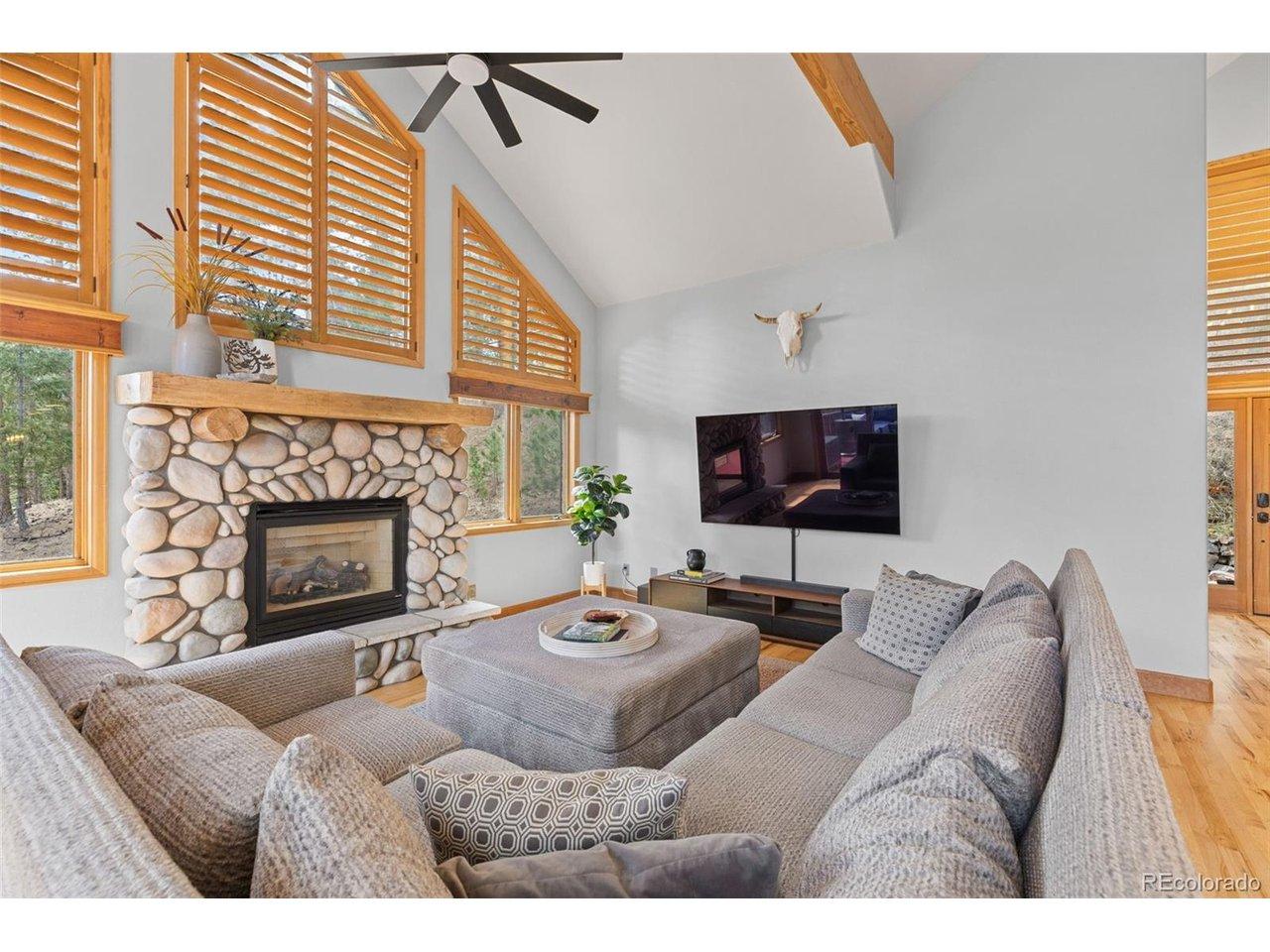 Image 4: Great room with a stone stacked gas fireplace, walls of windows and access to the main level deck. Image 4: Great room with a stone stacked gas fireplace, walls of windows and access to the main level deck.