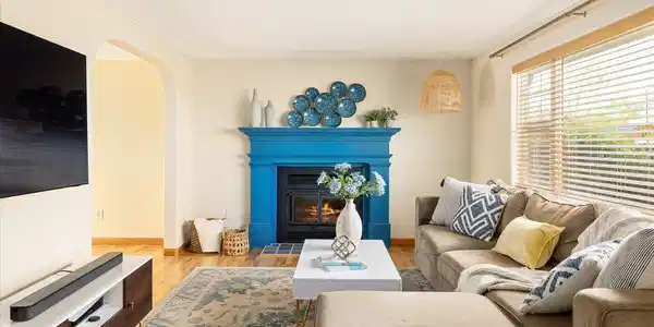 Image 2: bright and inviting living area with hardwood floors, abundant natural light and a cozy fireplace