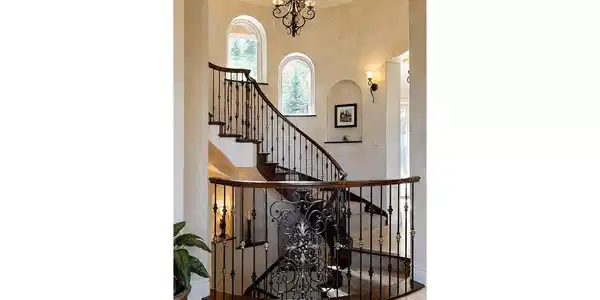 Image 4: A true architectural centerpiece, the home's magnificent self supported spiral staircase with natural lighting from arched windows with custom granite sills gracefully winds through all levels of the residence, creating a dramatic focal point that immediat