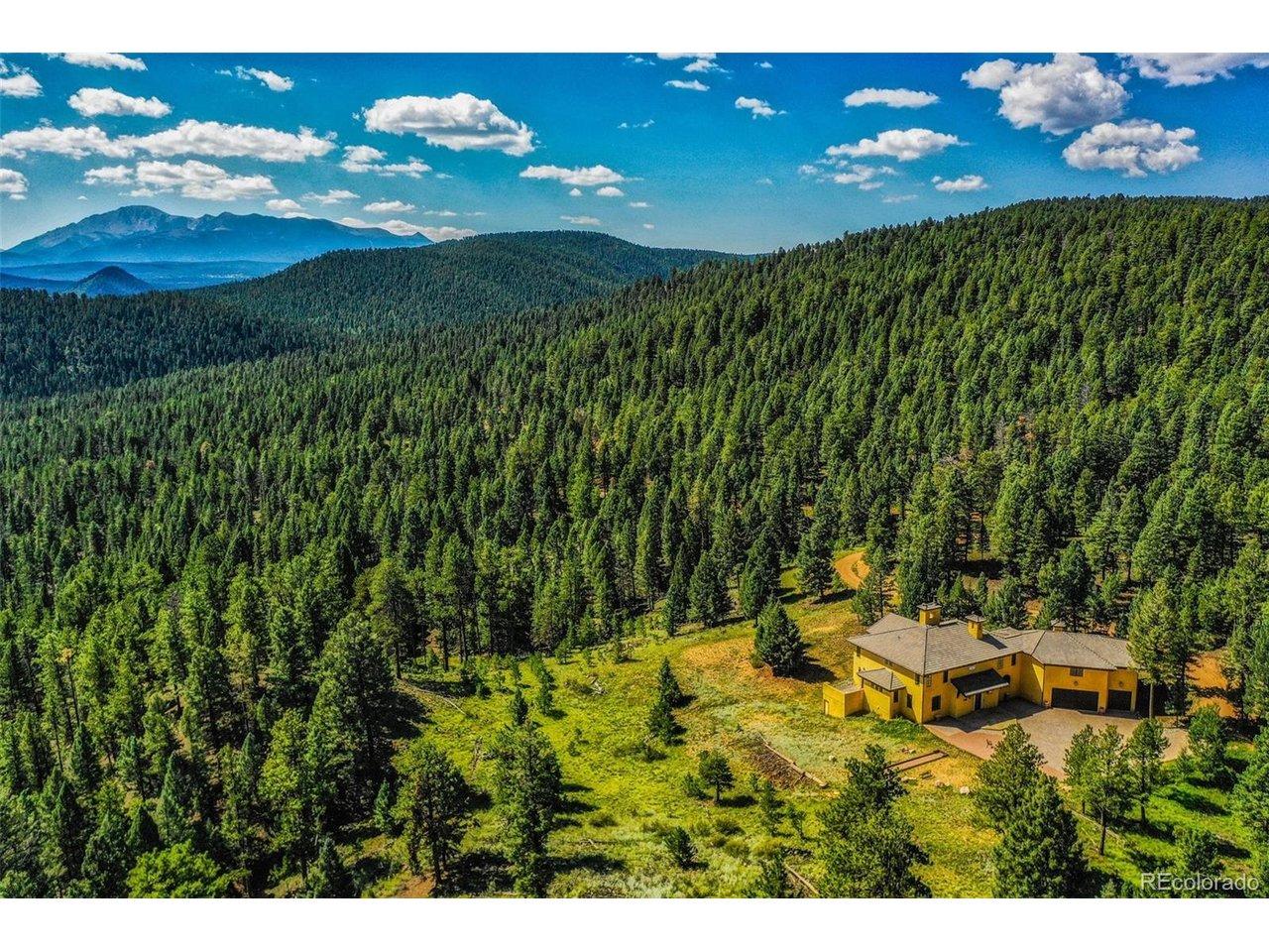 Image 4: Aerial view of the surrounding forested space and over the treetops to see the proximity of Pikes Peak.