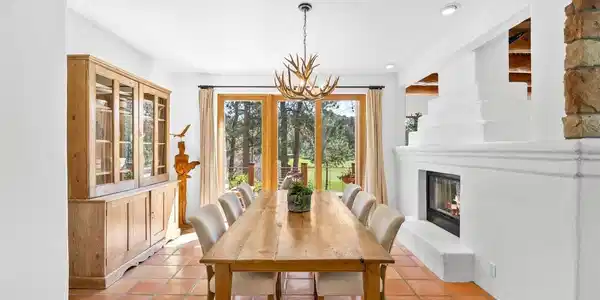 Image 3: Sunlit dining area framed by expansive windows and natural wood Image 3: Sunlit dining area framed by expansive windows and natural wood