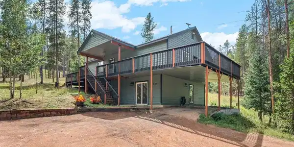 Image 2: Elevated on stilts above a sheltered lower level, this home makes the most of every angle - a wraparound upper deck for taking in the treetops, and a covered carport-style space below built for mountain practicality. Form and function, working together fro Image 2: Elevated on stilts above a sheltered lower level, this home makes the most of every angle - a wraparound upper deck for taking in the treetops, and a covered carport-style space below built for mountain practicality. Form and function, working together fro