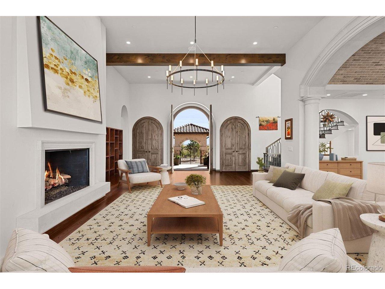 Image 2: Great room with soaring beamed ceilings, arched entry doors opening to the courtyard, and a gas fireplace. Virtually staged.