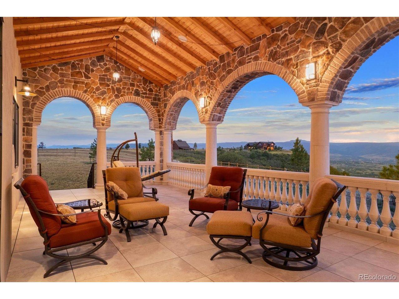 Image 4: Covered deck with stone arches, tongue-and-groove ceiling, and unobstructed Front Range views.