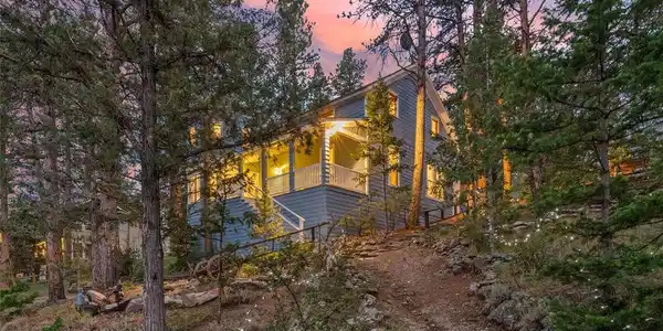 Image 3: A stone-lined path winds up through the trees, guiding you home beneath a sky painted in dusky pink and blue. Perched on the hillside, the home's porch light beckons at the top of the trail - a peaceful, private escape that feels a world away, yet is just Image 3: A stone-lined path winds up through the trees, guiding you home beneath a sky painted in dusky pink and blue. Perched on the hillside, the home's porch light beckons at the top of the trail - a peaceful, private escape that feels a world away, yet is just