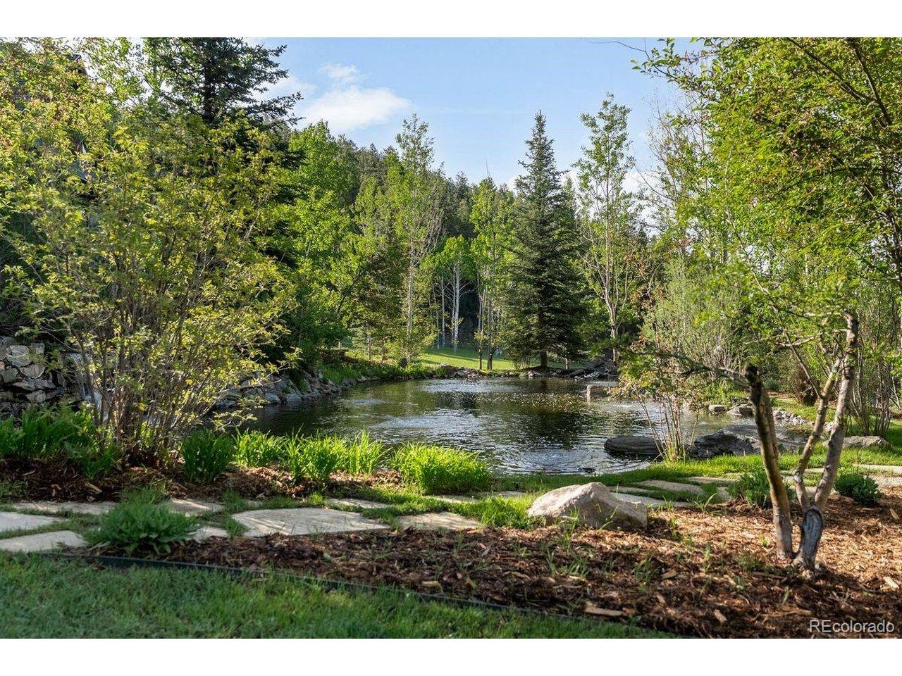 Image 3: pond adjacent to main home with multiple waterfalls & streams