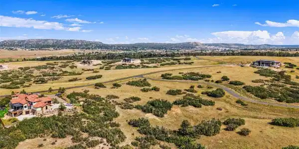Image 3: Aerial across rolling meadow and scrub oak toward the Front Range foothills Image 3: Aerial across rolling meadow and scrub oak toward the Front Range foothills