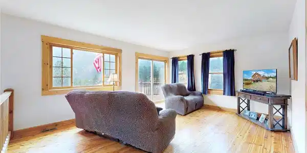 Image 4: See yourself relaxing in this main level living room filled with natural light as you look out on to the mountains. Image 4: See yourself relaxing in this main level living room filled with natural light as you look out on to the mountains.