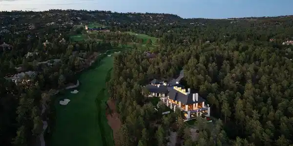 Image 2: Aerial view of the home along the 8th fairway of Castle Pines Golf Club. The home sits on nearly 7 acres surrounded by mature landscaping making.