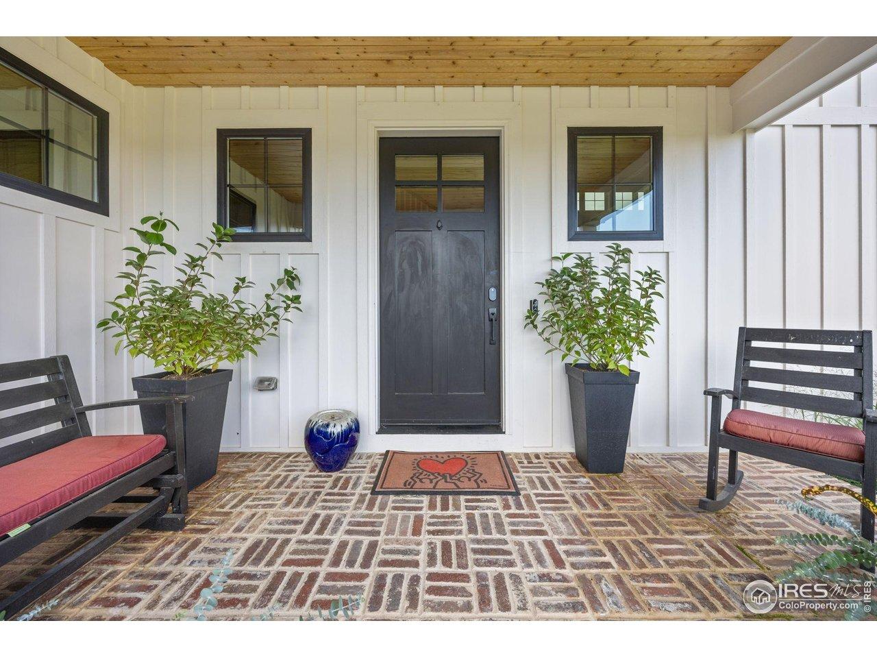 Image 4: Covered entry with charming brickwork offers an inviting welcome into the home.