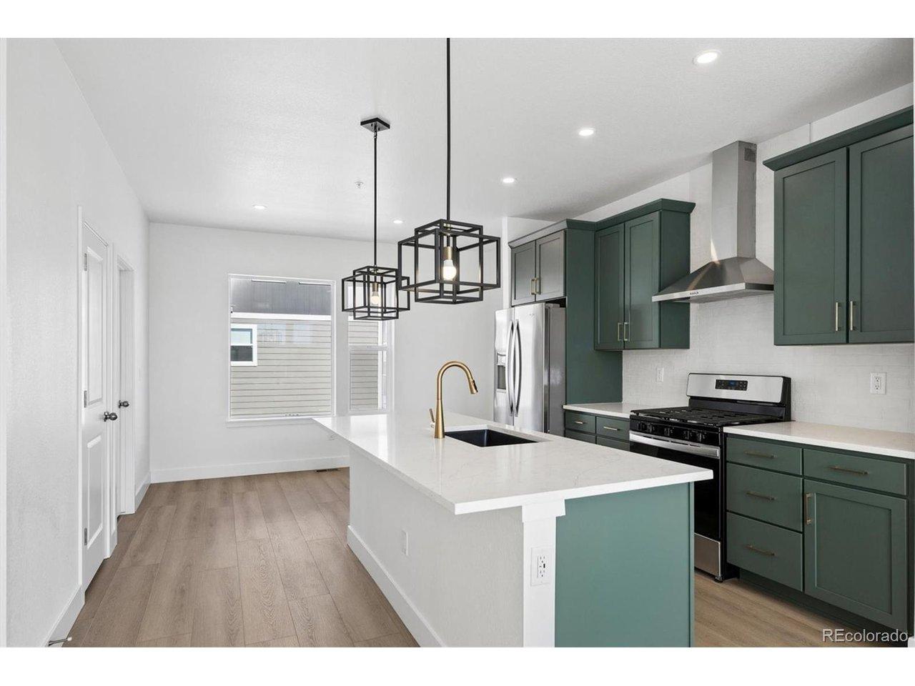 Image 3: Expansive Kitchen with Quartz Countertops and Stainless Steel appliances,